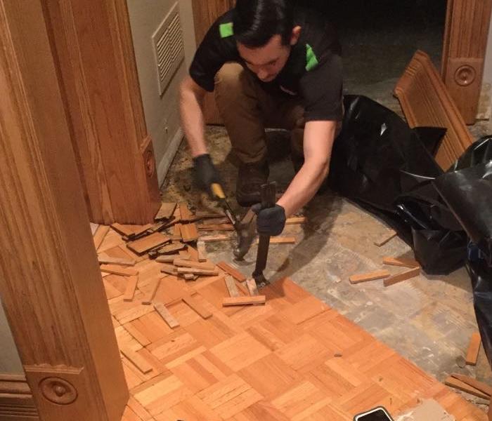 Team member tearing out wood floor