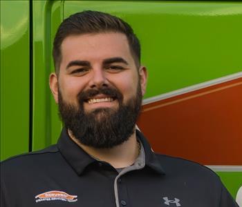 Zachary standing in front of one of our Servpro green trucks