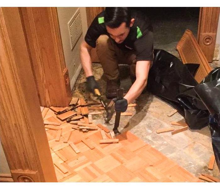 SERVPRO employee removing wood flooring 